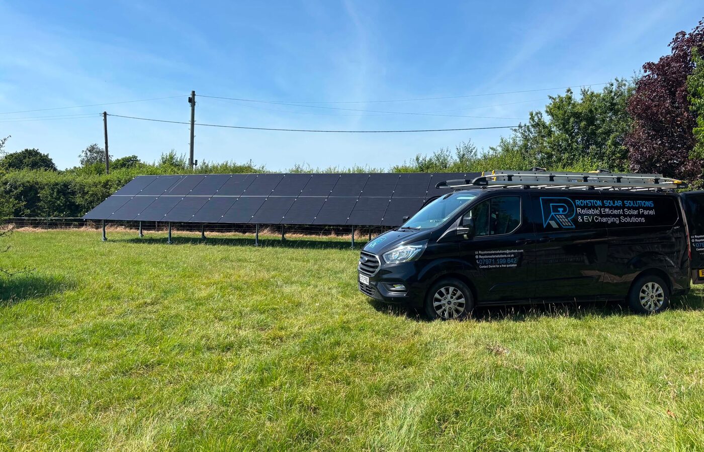 The Royston Solar Solutions van beside a ground mounted array
